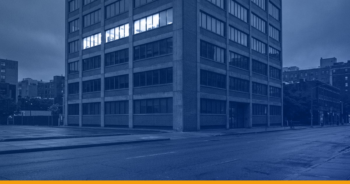 A commercial office building at night with one floor lit, under a Kardin navy gradient overlay.