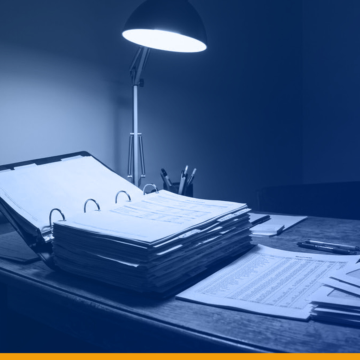 A property management desk at night: a thick budget binder and a printed rent roll under a single desk lamp, under a Kardin navy gradient overlay.